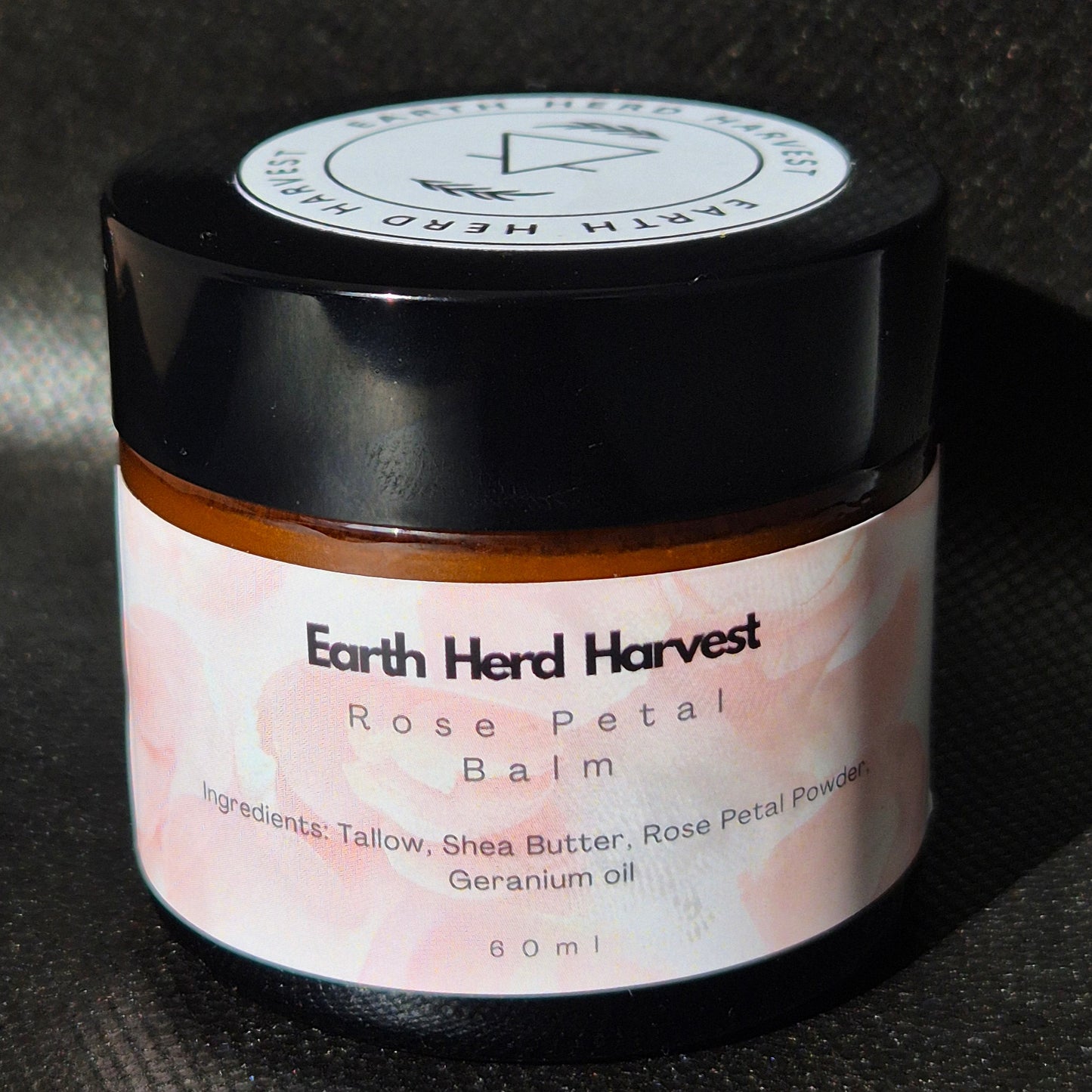 Earth Herd Harvest Rose Petal Balm jar on a dark background